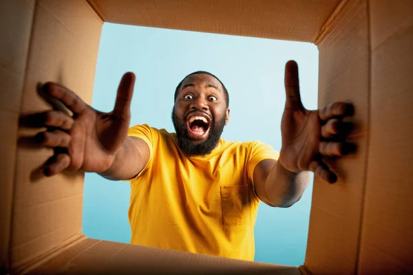 Happy Boy får ett paket från online shop order. glada och överraskade uttryck. Blå bakgrund — Stockfoto