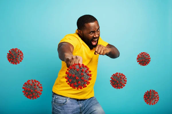 Людина атакує ковадлом 19 коронавірусом. Синій фон — стокове фото