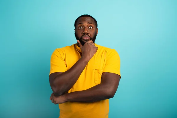 Confuse and pensive expression of a boy with many questions . cyan colored background — Stock Photo, Image