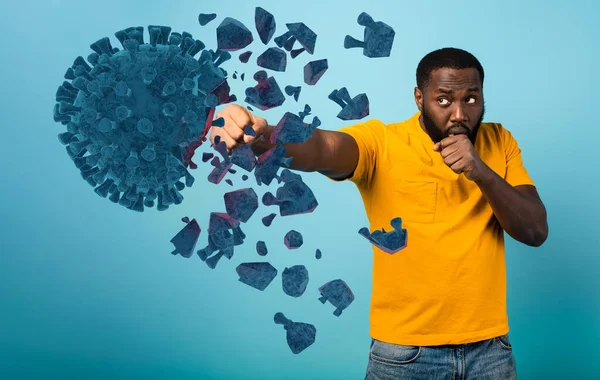 Man attacks with a punch the coronavirus. Blue background — Stock Photo, Image