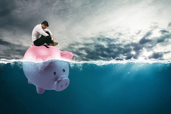 Geschäftsmann in finanziellen Schwierigkeiten segelt wegen Krise auf Sparschwein in schlechtem Fahrwasser — Stockfoto