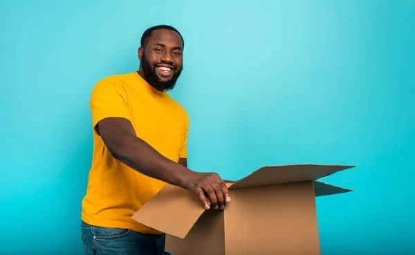 Niño feliz recibe un paquete de orden de la tienda en línea. Fondo azul. —  Fotos de Stock