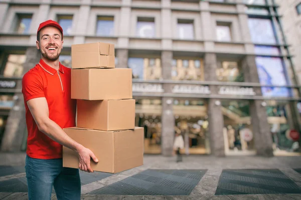Mensajero rojo afuera lleva paquetes para entregas de envíos . —  Fotos de Stock