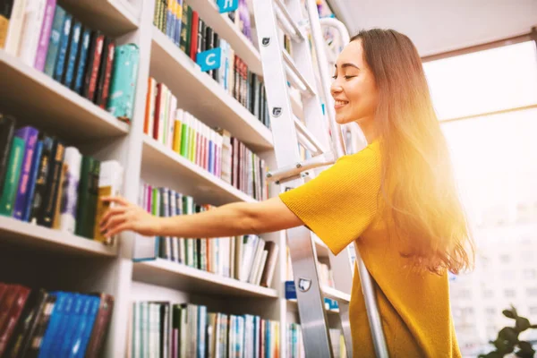 Meisje kiest een boek om te lezen. Concept van cultuur en studie. — Stockfoto