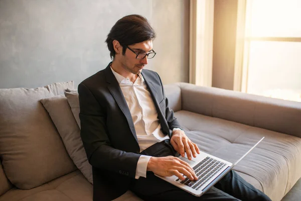 Uomo d'affari lavora da remoto a casa con un computer portatile a causa di quarantena coronavirus . — Foto Stock