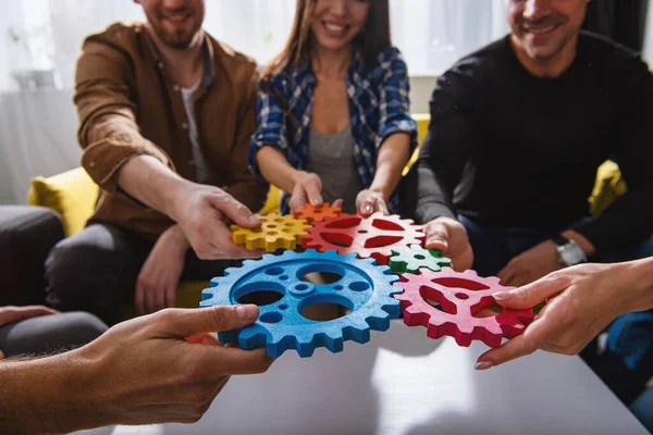 Zakenteam verbinden stukken tandwielen. Teamwork, partnerschap en integratie — Stockfoto