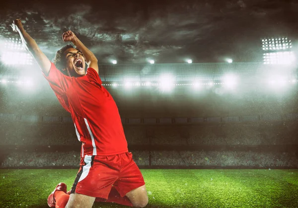 Atacador de futebol em uniforme vermelho se alegra pela vitória no estádio — Fotografia de Stock