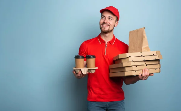 Courier is happy to deliver hot coffee and pizza. Cyan background — Stock Photo, Image