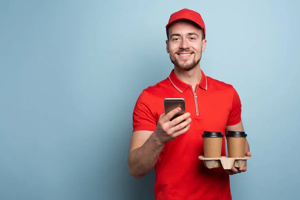 Courier está feliz de entregar café caliente y comida. Antecedentes cian — Foto de Stock