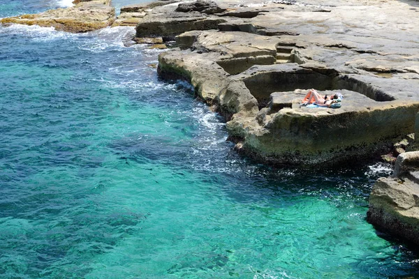 MALTA - 21 DE ABRIL: Las dos mujeres están en la playa el 21 de abril de 2015 en Malta. Más de 1,6 millones de turistas se espera que visite Malta en el año 2015 . —  Fotos de Stock