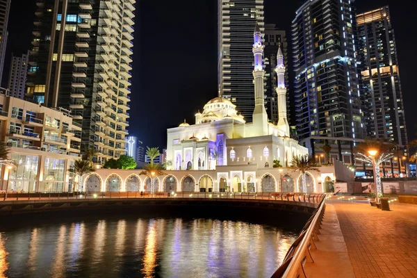 DUBAI, UAE - NOVEMBER 19: The night illumination of Dubai Marina and Muslim Mosque on November 19, 2017 in Dubai, UAE. It is an artificial canal city, built along a two mile (3 km) stretch of Persian Gulf shoreline. — Stock Photo, Image