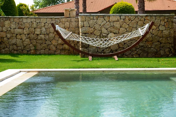 The hammock is on lawn and swimming pool at luxury villa, Antalya, Turkey — Stock Photo, Image