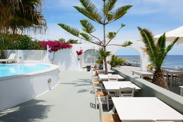 El restaurante al aire libre cerca de la playa, isla de Santorini, Grecia —  Fotos de Stock