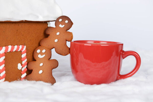 Имбирный домик ручной работы, маленькие человечки и чашка кофе
