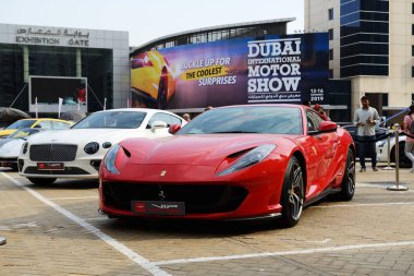 DUBAI, UAE - NOVEMBER 16: The Ferrari 812 Superfast and Bentley Continental GT sportscars are on Dubai Motor Show 2019 on November 16, 2019  clipart