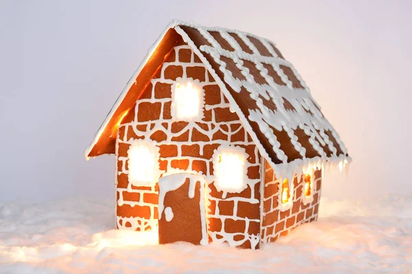 Het handgemaakte eetbare peperkoek huis met licht binnen en sneeuw decoratie — Stockfoto