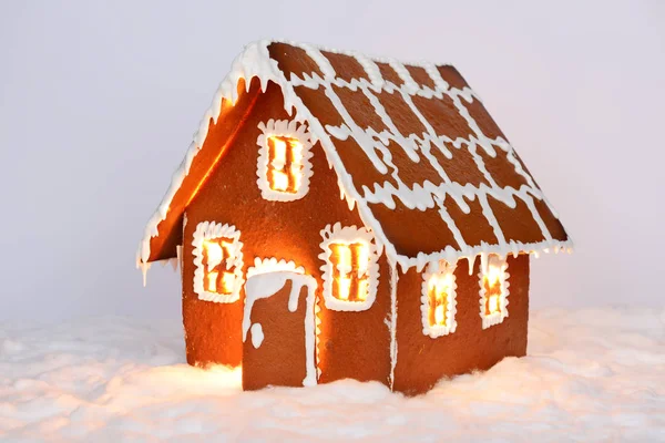 The hand-made eatable gingerbread house with light inside and snow decoration — Stock Photo, Image