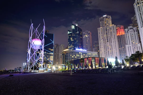 DUBAI, Emiratos Árabes Unidos - 15 de noviembre: La cena en el restaurante Sky y la iluminación nocturna de playa en Jumeirah Beach Residence el 15 de noviembre de 2019 en Dubai, Emiratos Árabes Unidos. — Foto de Stock