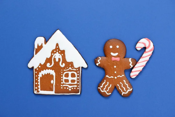 Das handgemachte Lebkuchenhaus, kleine Männer mit Karamell auf blauem Hintergrund — Stockfoto