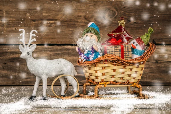 Santa y muñeco de nieve en un trineo de renos con regalos . — Foto de Stock