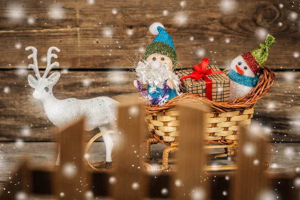 Santa y muñeco de nieve en un trineo de renos con regalos . — Foto de Stock