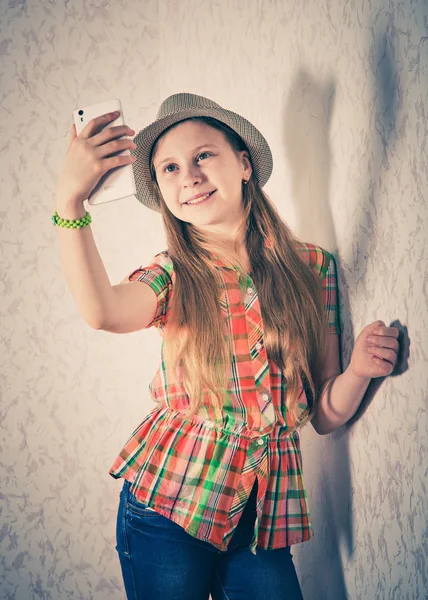 Fille gaie en casquette et faire du selfie sur smartphone . — Photo