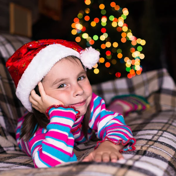 Happy child girl in a Christmas hat waiting for a miracle. — Stock Photo, Image