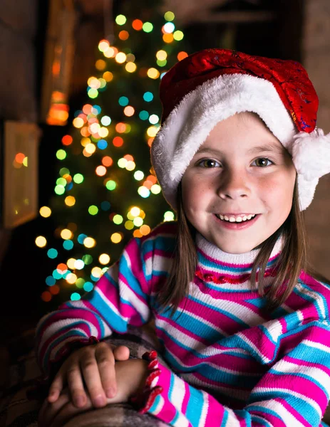 Happy child girl in a Christmas hat waiting for a miracle. — Stock Photo, Image