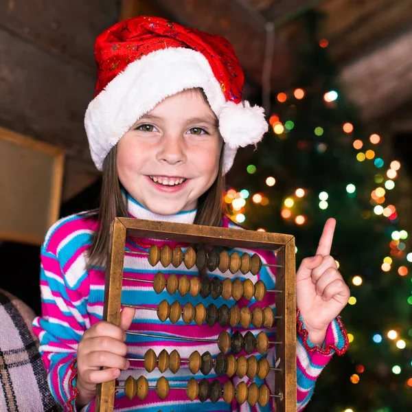 Happy child girl in a Christmas hat waiting for a miracle. — Stock Photo, Image