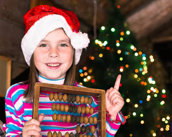 Happy child girl in a Christmas hat waiting for a miracle. — Stock Photo, Image