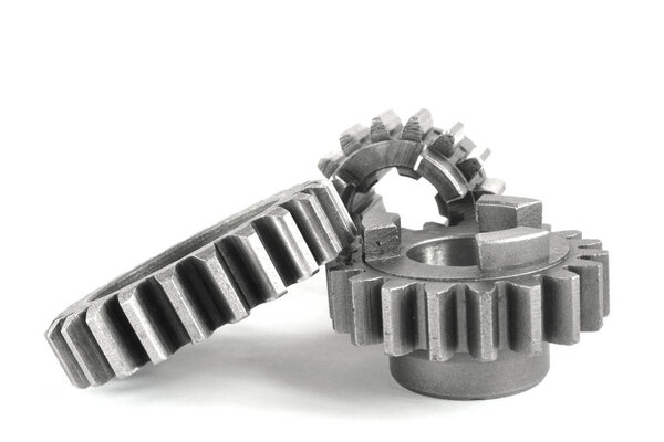 Три металлические шестерни на белом фоне
