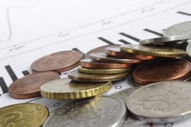 Farklı sikke ve grafik ile finansal arka plan.