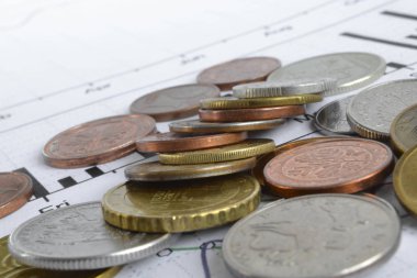 Farklı sikke ve grafik ile finansal arka plan.