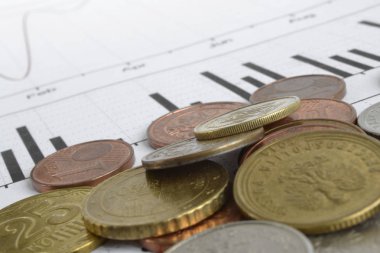 Farklı sikke ve grafik ile finansal arka plan.