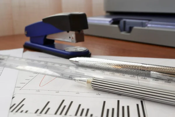 Business background with graph, ruler, pen and stapler — Stock Photo, Image