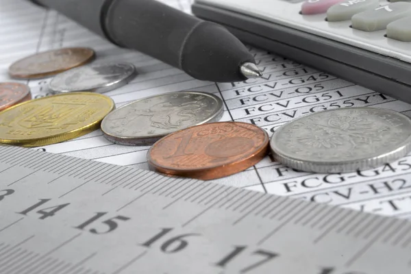 Financiële achtergrond met verschillende munten, liniaal en tafel — Stockfoto