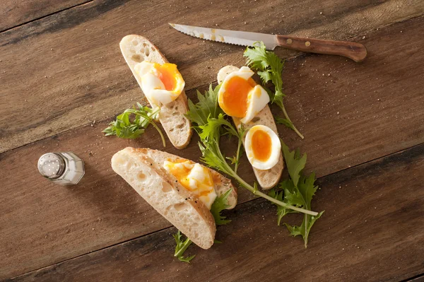 Soft cooked eggs sliced and served on bread — Stock Photo, Image