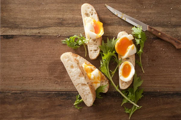 Sliced soft boiled eggs on fresh baguette — Stock Photo, Image