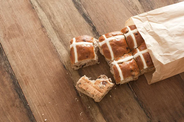 Brunt papper packet med färska heta kors bullar — Stockfoto