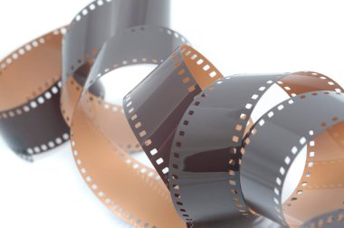35 mm 'lik eski film negatiflerinin sarmalanmış sarmalı beyaz bir arka planda gelişmiş çerçeveler ve prizler ile fotoğraf konseptinde