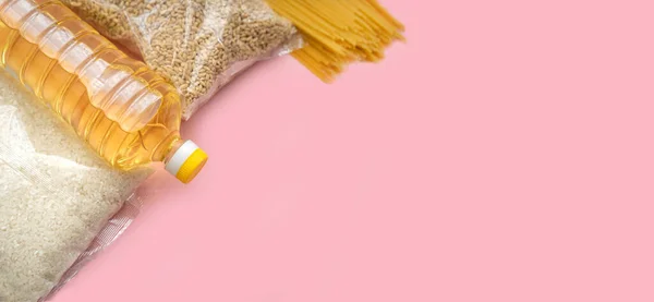 Gıda tedariği krizi yiyecek stoku karantina dönemi izolasyonu pembe arka planda. Pirinç, makarna, arpa, tereyağı. Yemek Teslimatı, Bağış, Koronavirüs Karantinası.