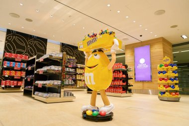 Doha, Katar - Mayıs, 2017 yaklaşık: M ve M Hamad Uluslararası Havaalanı, Doha, Katar başkenti şehir ekranda sarı karakter şeker..