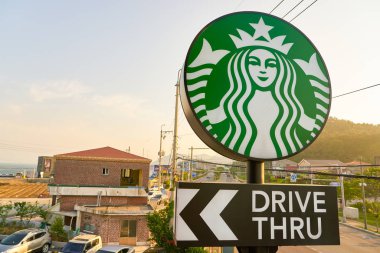 Busan, Güney Kore - Mayıs, 2017 yaklaşık: sürücü-thru Starbucks kafede Busan tabelaya. Şirket ve kahvehane bir Amerikan kahve zinciri Starbucks kuruluştur.