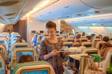 Singapur - 03 Kasım 2015: uçuş görevlisi hizmet yiyecek ve içecek Singapur Hava Yolları'nın Airbus A380, uçaktaki yolcuları için