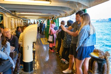 Hong Kong, Çin - Ocak 2019: Victoria Limanı 'ndan geçen bir Star Ferry' deki insanlar. Star Ferry, Hong Kong 'da bir yolcu feribot operatörü ve turistik merkezdir..