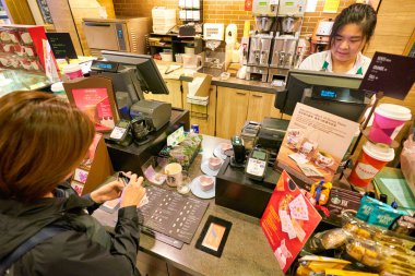 HONG KONG, CHINA - CIRCA JANUARY, 2019: staff taking an order from woman at Starbucks Coffee in Hong Kong.