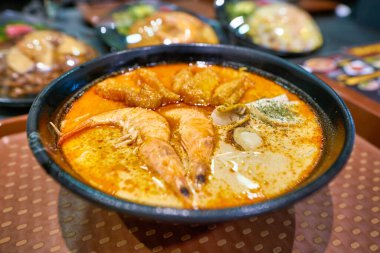 Singapur - Nisan 2019: Marina Körfezi Sands 'deki Shoppes' de görev yapan deniz mahsulleri Laksa 'nın yakın çekimi. Laksa, Güneydoğu Asya 'nın Peranakan mutfağında popüler bir baharatlı şehriye çorbası.