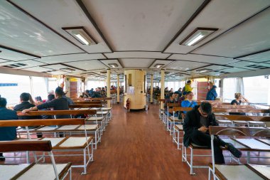 Hong Kong, Çin - Ocak 2019: Victoria Limanı 'ndan geçen bir Star Ferry' deki insanlar. Star Ferry, Hong Kong 'da bir yolcu feribot operatörü ve turistik merkezdir..