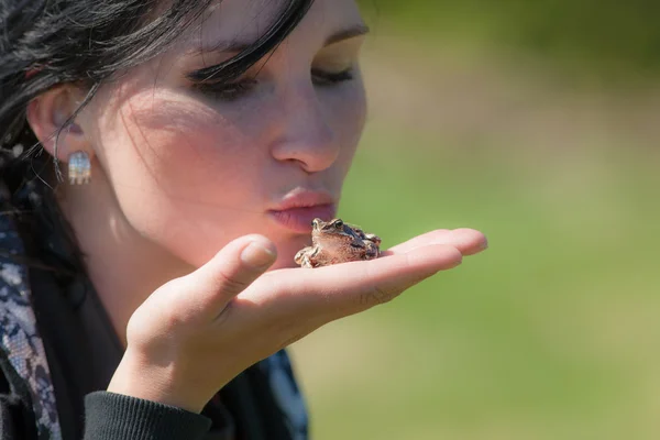 Meisje houdt een kikker — Stockfoto