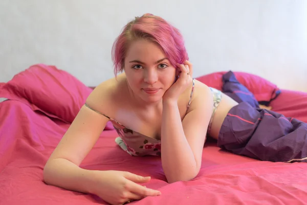 Meisje in pyjama op het bed — Stockfoto